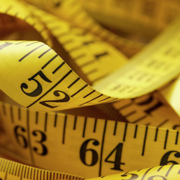 a bundle of yellow fabric measuring tape with some number labels clearly readable.